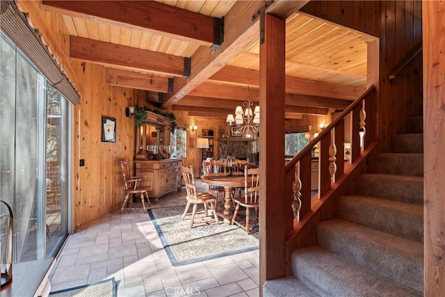 dining space with beam ceiling, wooden ceiling, wood walls, and a notable chandelier