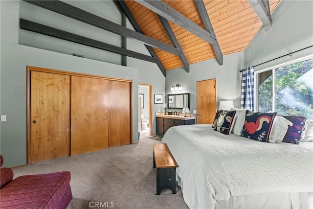 bedroom with ensuite bathroom, wooden ceiling, light colored carpet, high vaulted ceiling, and beamed ceiling