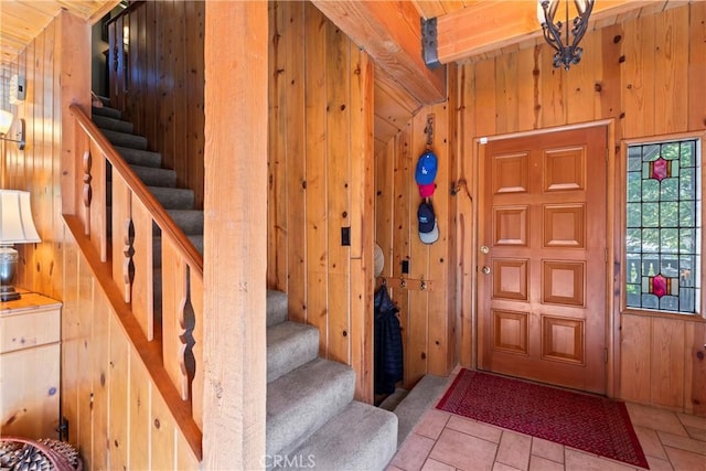 foyer entrance featuring wooden ceiling, wooden walls, and beamed ceiling