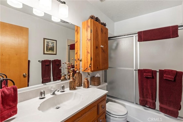 full bathroom with enclosed tub / shower combo, vanity, and toilet