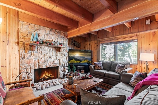 living room with wooden ceiling, beam ceiling, a fireplace, and wooden walls