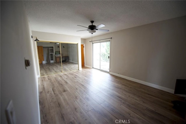 empty room with hardwood / wood-style flooring, ceiling fan, and a textured ceiling