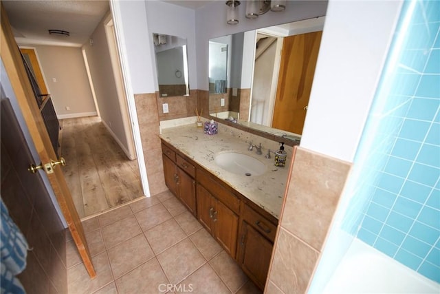 bathroom with tile patterned flooring, vanity, and tile walls