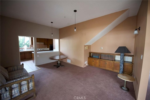 carpeted living room featuring vaulted ceiling