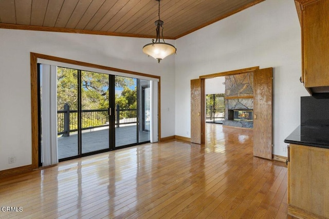 interior space with a healthy amount of sunlight, light wood-type flooring, a fireplace, and wood ceiling