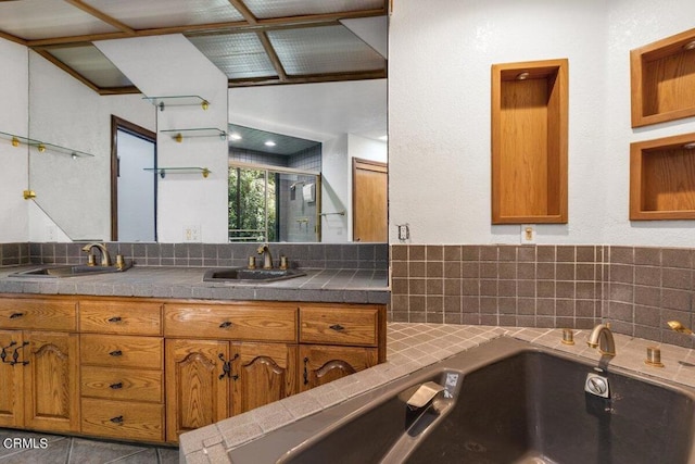 bathroom with tile flooring, oversized vanity, a tub, and dual sinks