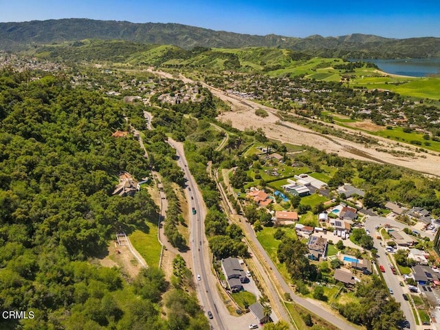 birds eye view of property with a water and mountain view