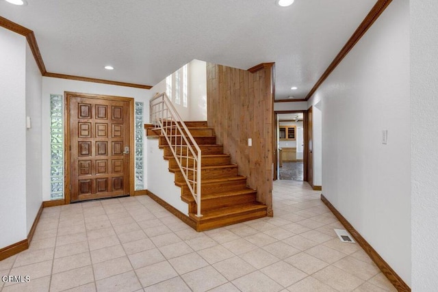 tiled foyer entrance with crown molding