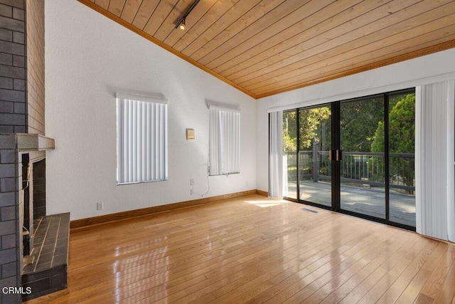 unfurnished room featuring wooden ceiling, light hardwood / wood-style flooring, track lighting, and a fireplace