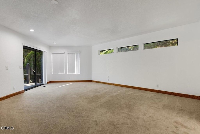 unfurnished room with a textured ceiling and carpet floors