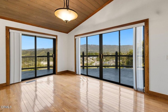 spare room with vaulted ceiling, light hardwood / wood-style floors, a healthy amount of sunlight, and wood ceiling