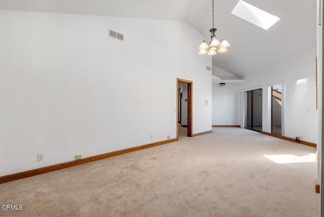 carpeted empty room with a skylight, high vaulted ceiling, and a chandelier