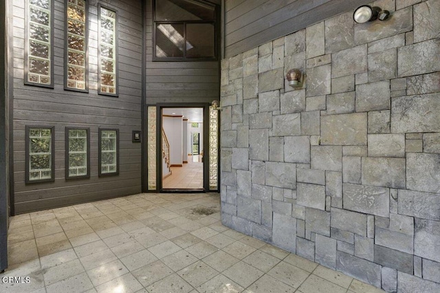 bathroom with wood walls and tile floors