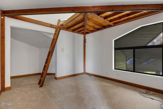 empty room with carpet and vaulted ceiling with beams