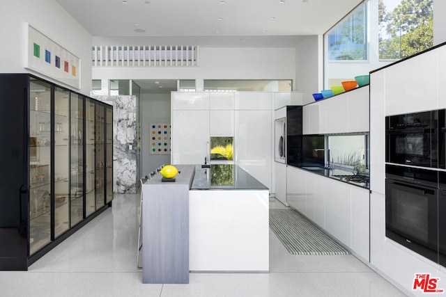 kitchen with black double oven and white cabinetry