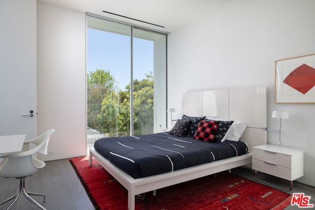 bedroom featuring hardwood / wood-style floors and a wall of windows