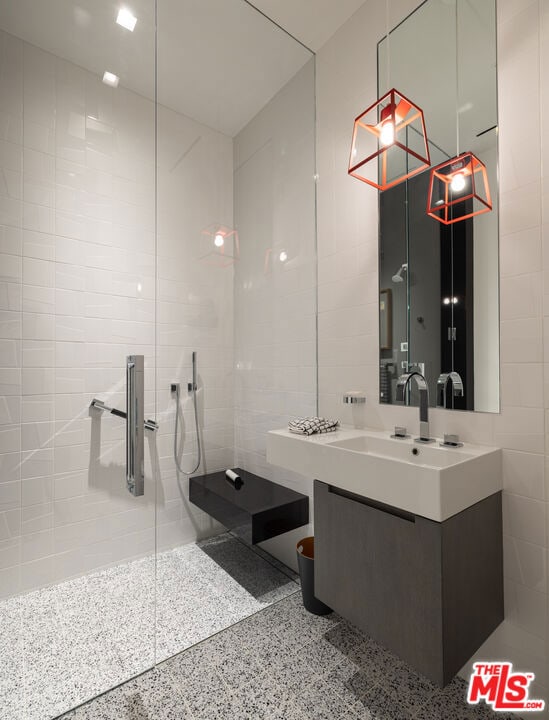 bathroom with vanity, tile walls, and a tile shower