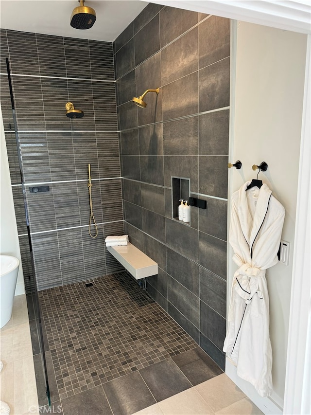 bathroom with tiled shower and tile patterned floors