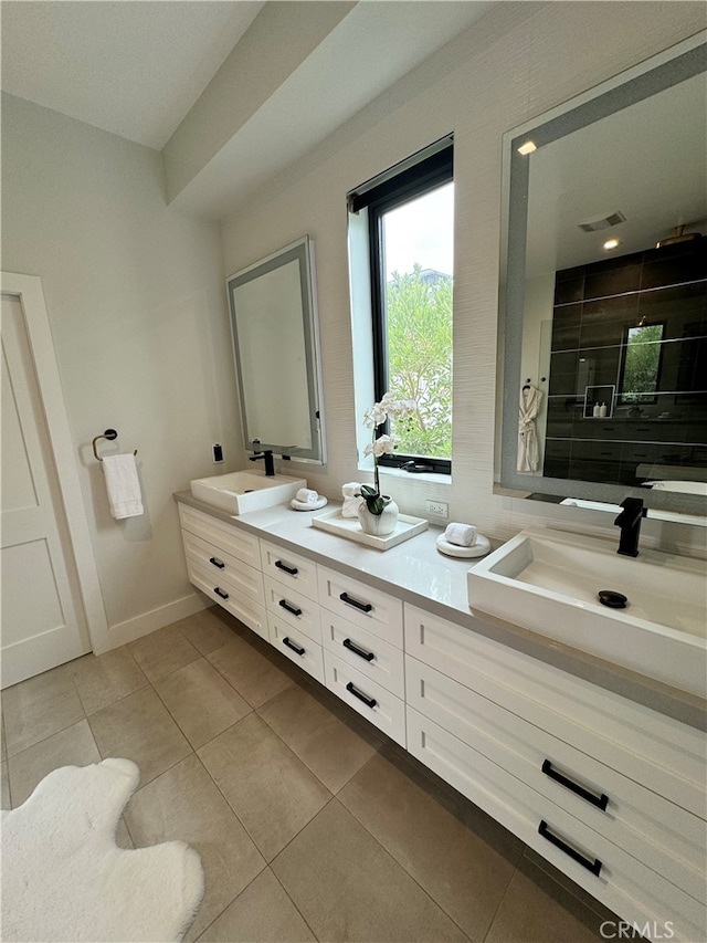 bathroom featuring vanity, a tile shower, and tile patterned flooring