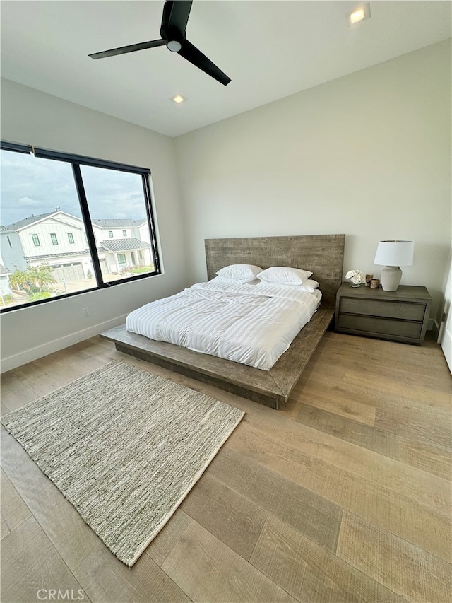 bedroom with light hardwood / wood-style flooring and ceiling fan