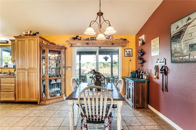 tiled dining area featuring plenty of natural light, lofted ceiling, sink, and a chandelier