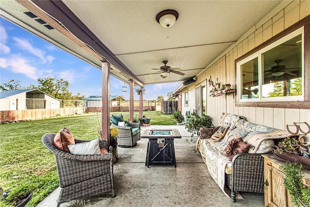 view of patio featuring ceiling fan and an outdoor living space with a fire pit