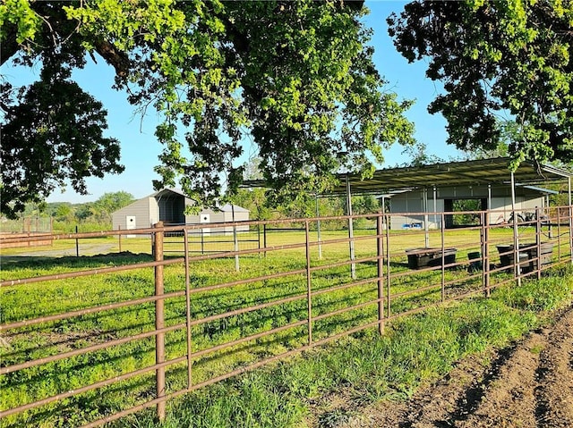 view of yard with a rural view and an outdoor structure