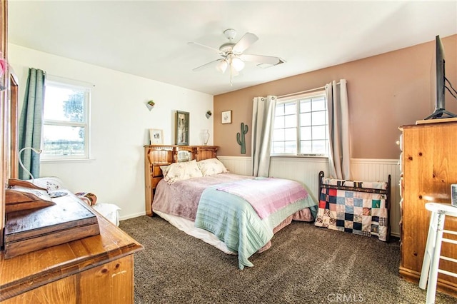 carpeted bedroom featuring multiple windows and ceiling fan