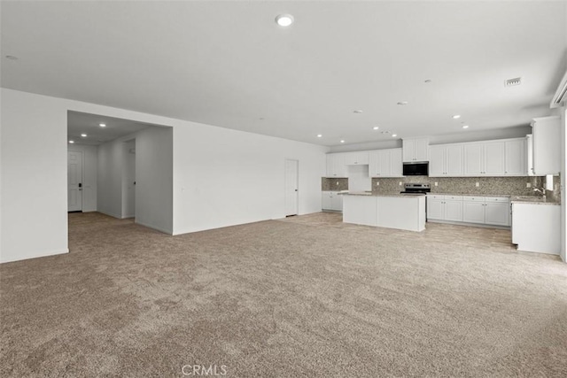 unfurnished living room featuring light colored carpet