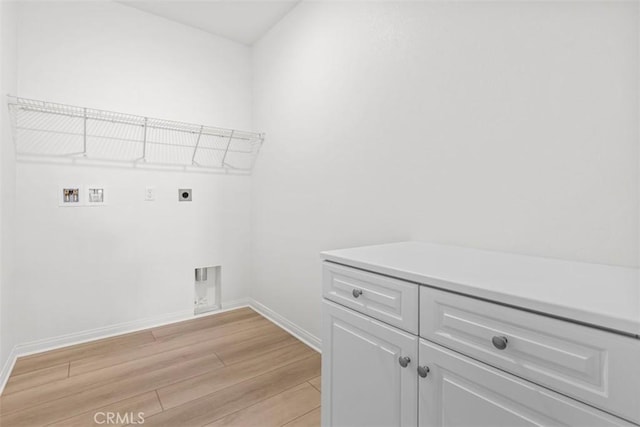 clothes washing area with cabinets, electric dryer hookup, washer hookup, and light wood-type flooring