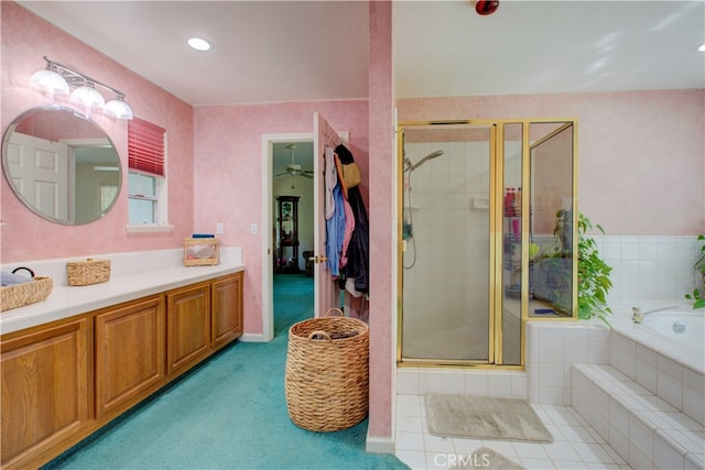 bathroom featuring ceiling fan, vanity, and plus walk in shower