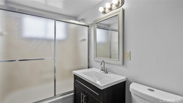 full bathroom with shower / bath combination with glass door, vanity, and toilet