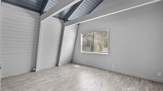 unfurnished room with wood ceiling, lofted ceiling with beams, and light wood-type flooring