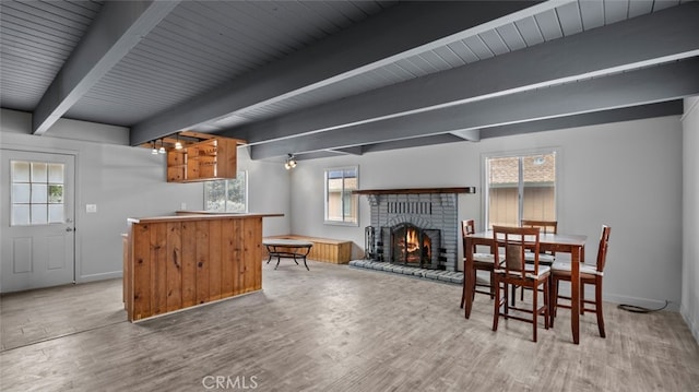 dining room with hardwood / wood-style flooring, a wealth of natural light, and beam ceiling