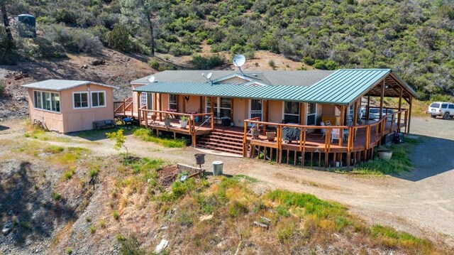 rear view of property featuring a wooden deck