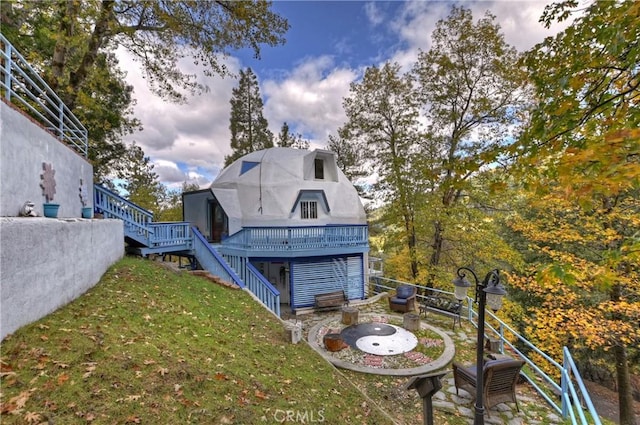 rear view of house featuring a yard and a wooden deck