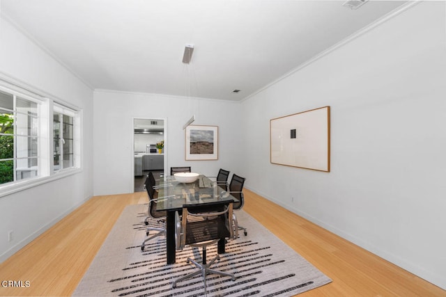 dining area featuring hardwood / wood-style flooring and ornamental molding