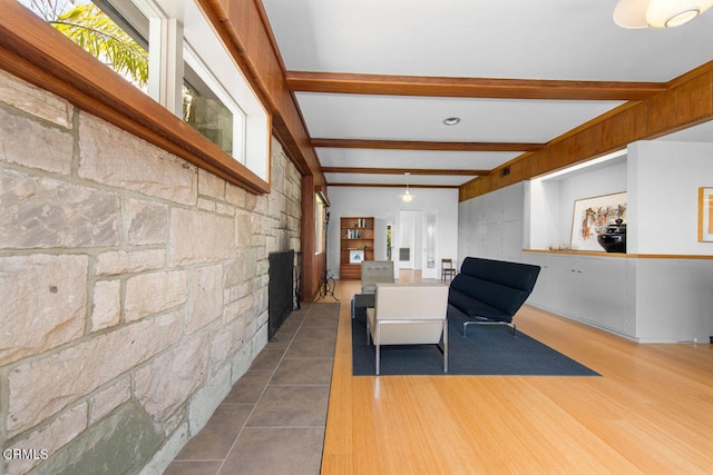 tiled living room featuring beam ceiling