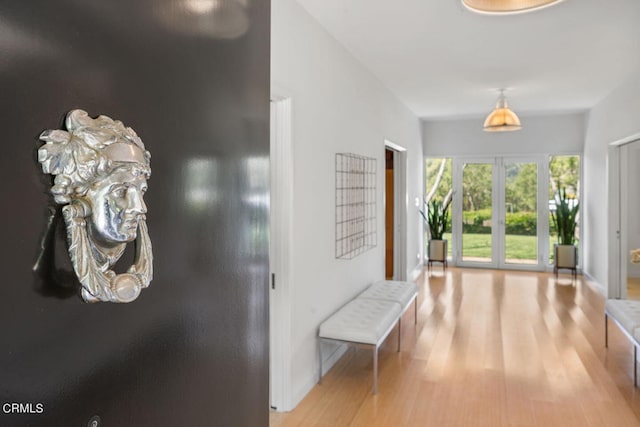 hallway with french doors and light hardwood / wood-style floors