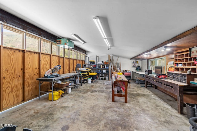 garage featuring wood walls and a workshop area