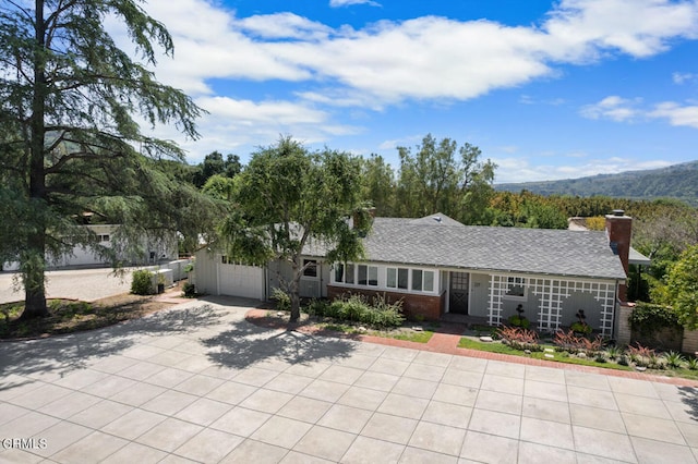 single story home with a garage and a mountain view