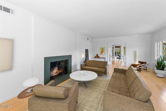 living room with crown molding and hardwood / wood-style flooring