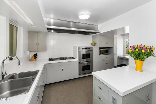 kitchen with sink, appliances with stainless steel finishes, backsplash, and gray cabinets