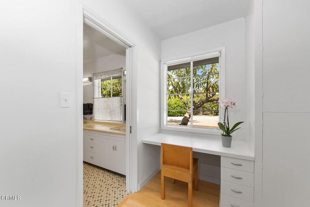 office area featuring a healthy amount of sunlight, built in desk, and light tile floors