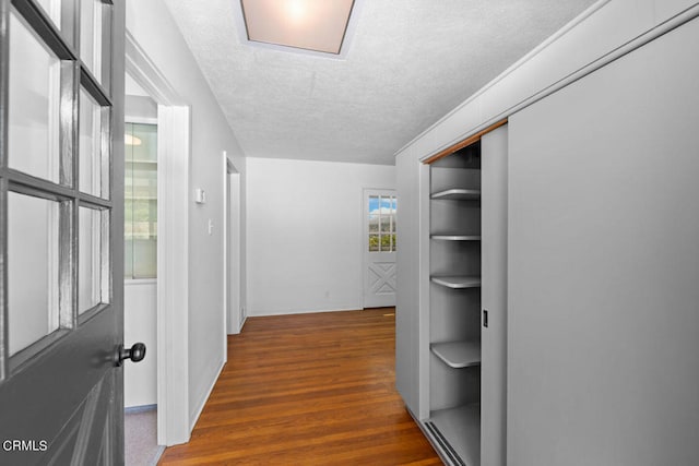 corridor featuring dark hardwood / wood-style floors and a textured ceiling