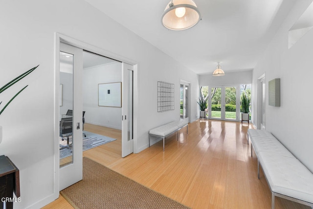 hallway with light hardwood / wood-style flooring and french doors