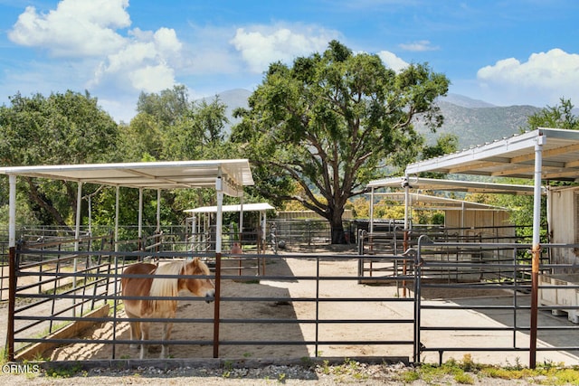 view of horse barn with a mountain view and an outdoor structure