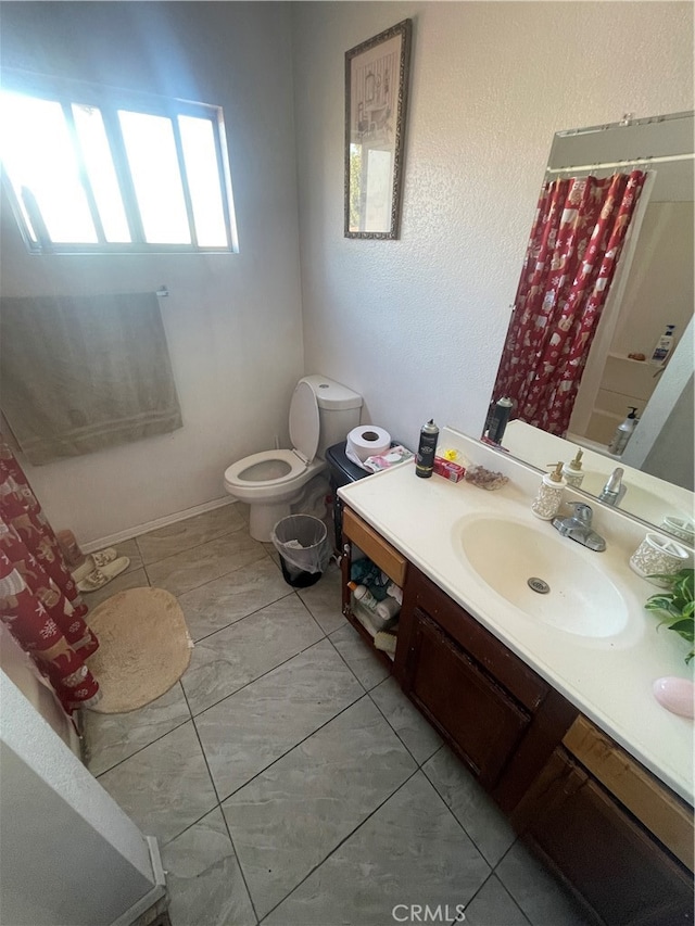 bathroom featuring toilet, vanity with extensive cabinet space, and tile flooring