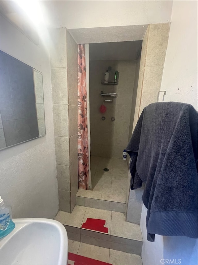 bathroom featuring tile flooring and a shower with shower curtain