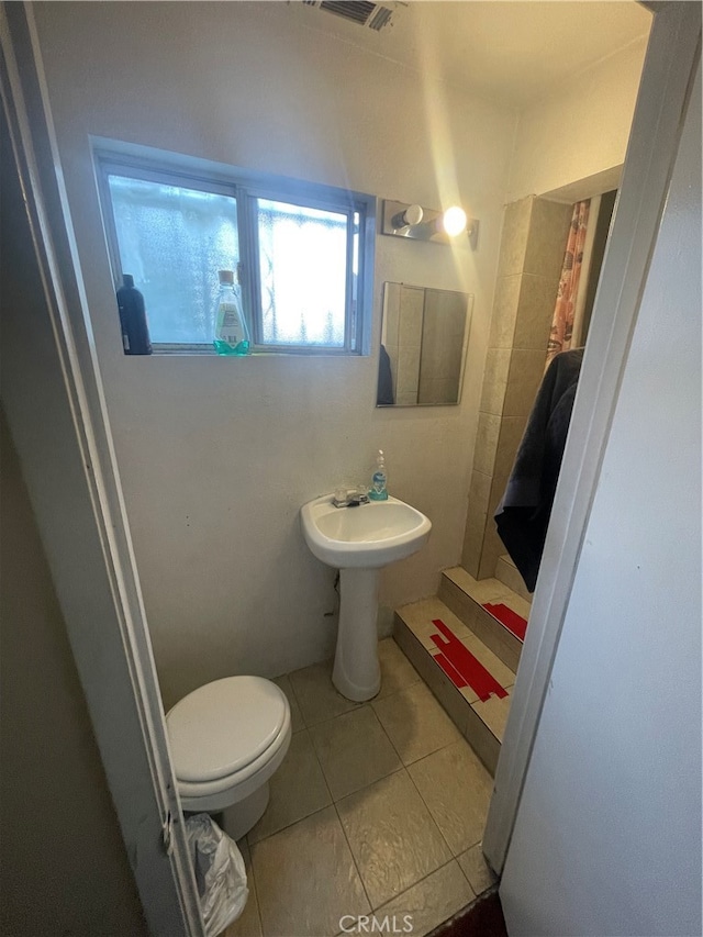 bathroom with toilet and tile flooring